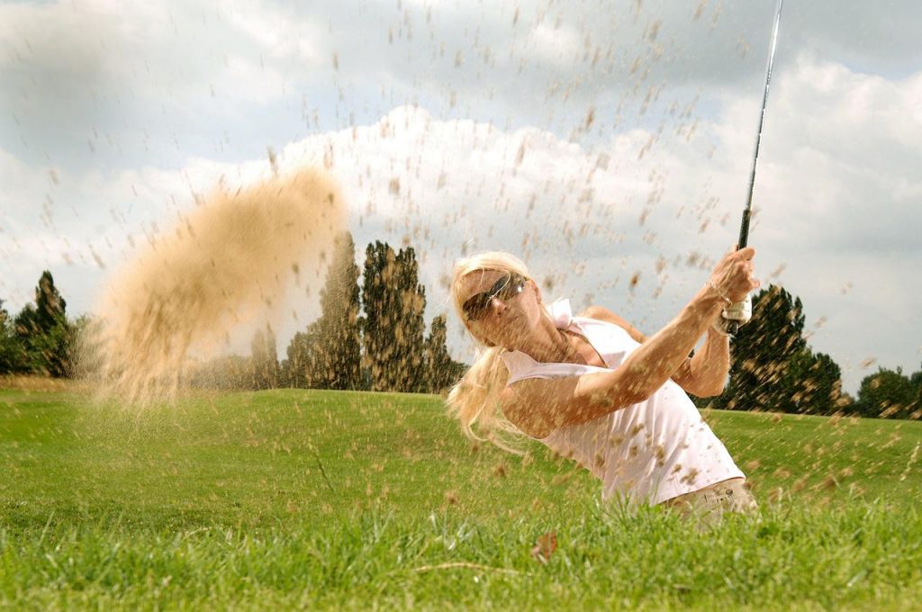 hitting a golf ball out the sand